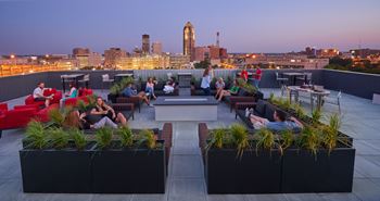 A roof top lounge with a city skyline in the background